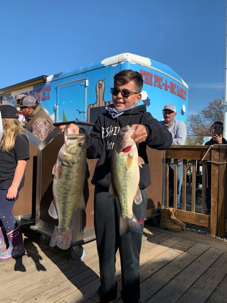 A &quot;freshly faded&quot; James Dammann holds up two big bass that helped him win the YAL Championship